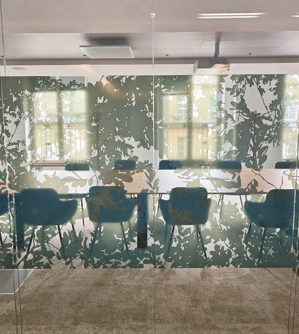 Salle de réunion vitrée habillée d'un décor végétal vert sur toute la hauteur